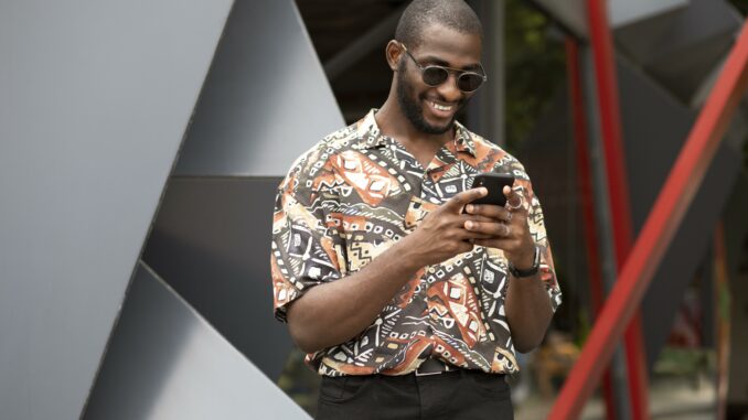 handsome-man-spending-time-outdoors-using-modern-smartphone