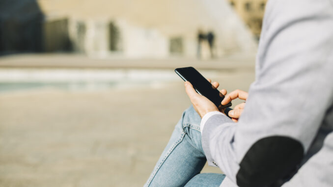 modern-businessman-using-smartphone-outdoors